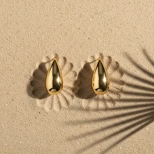 Golden earrings on beach sand