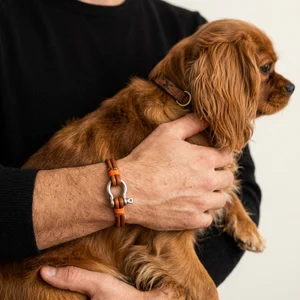 Man holding dog with bracelet