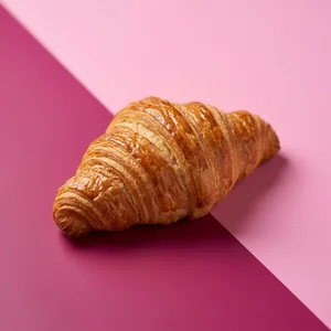 Gourmet croissant on pink gradient