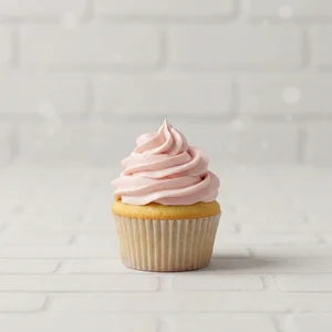 Pink frosted cupcake on white brick