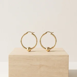 Minimalist gold earrings on wood