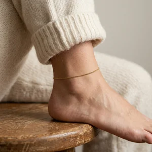 Elegant gold anklet on rustic wood