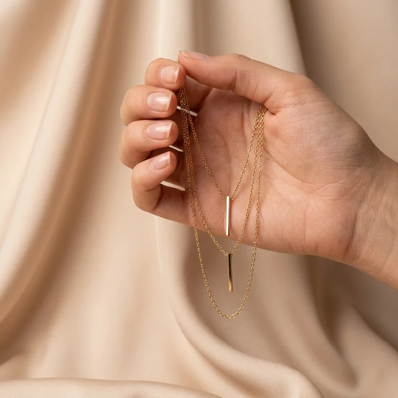 Gold layered necklace in hand