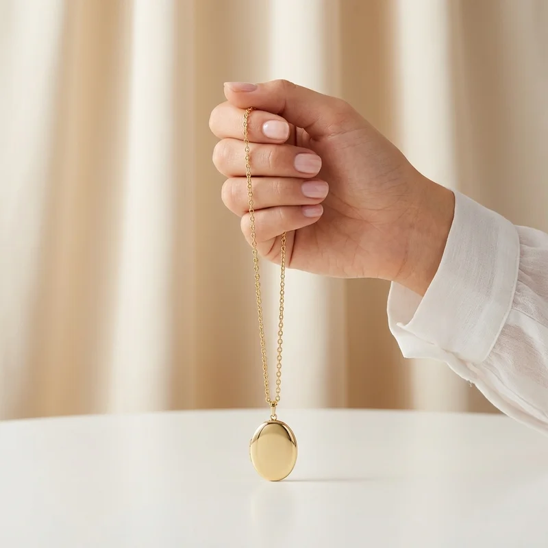 Hand holding gold locket necklace
