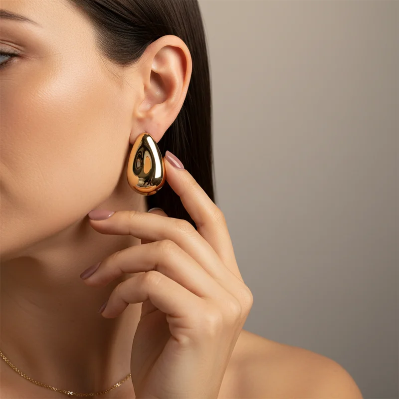 Elegant gold teardrop earring on model