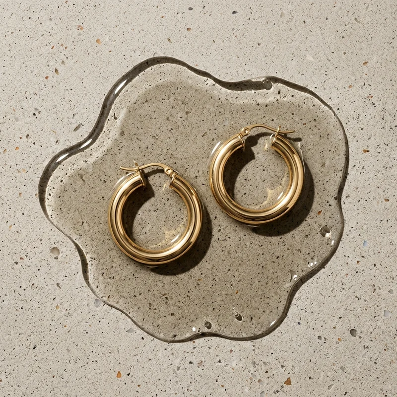 Gold hoops on concrete with water