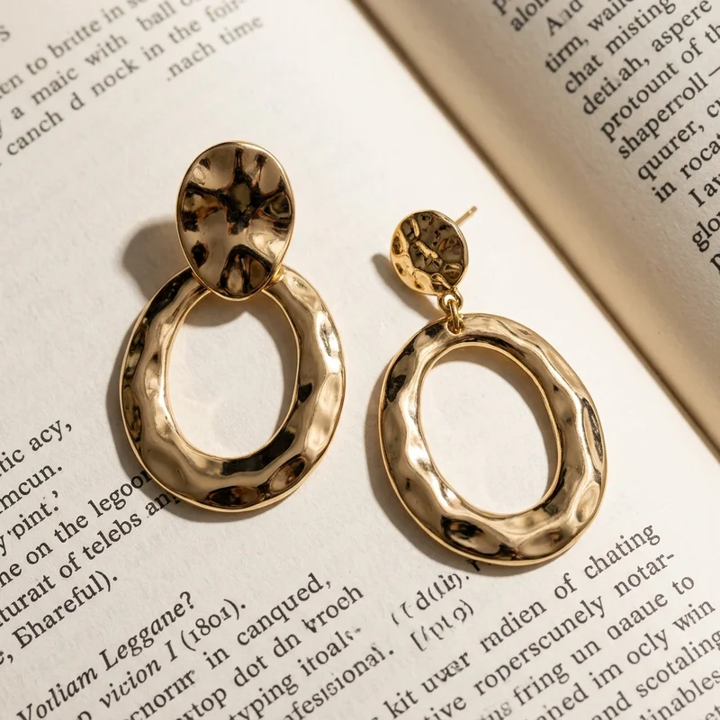 Gold earrings on open book
