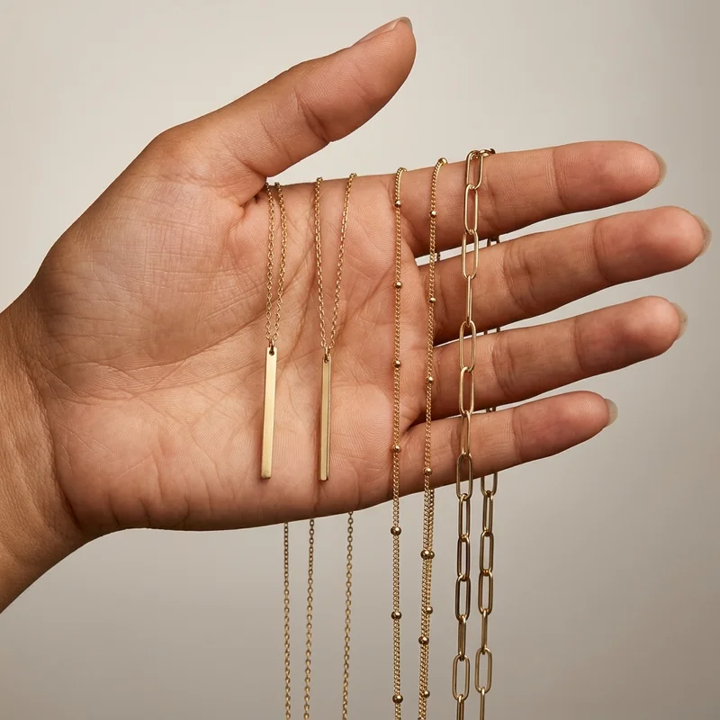 Layered gold necklaces in hand