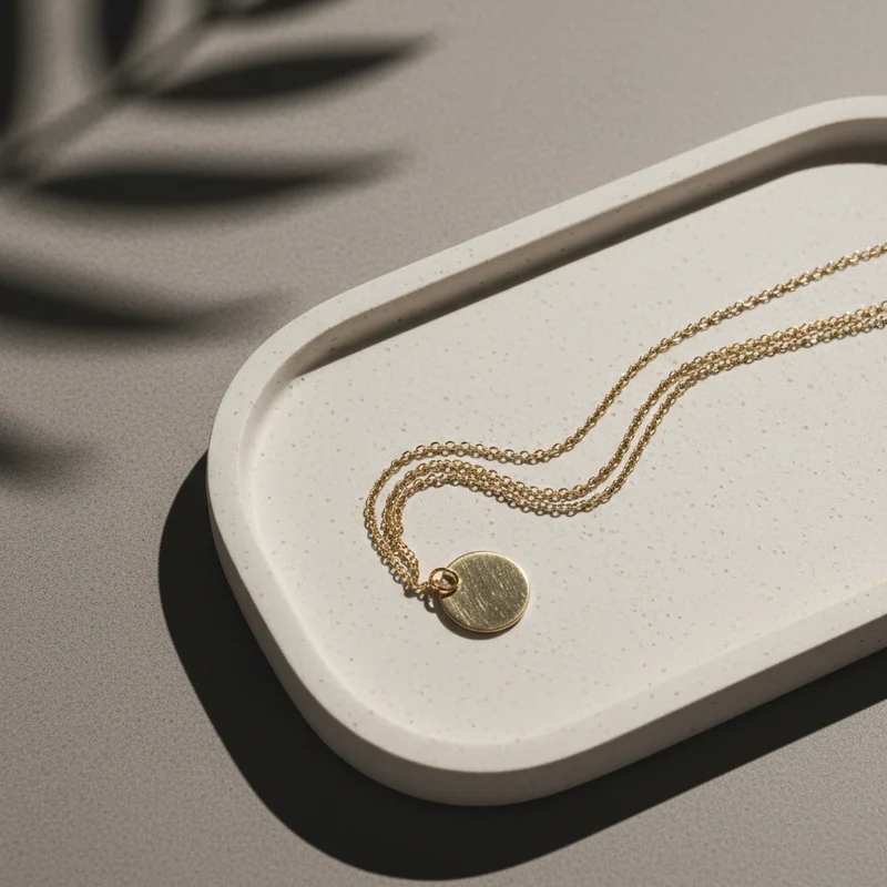 Minimalist gold necklace on terrazzo