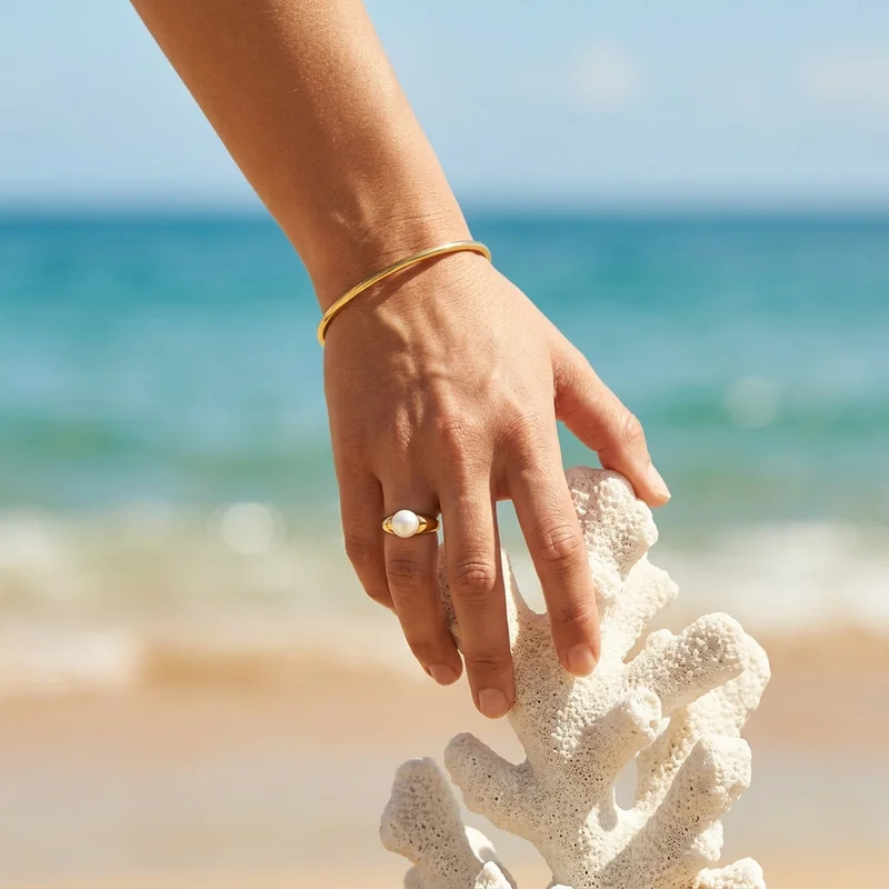 Pearl ring and gold on the beach
