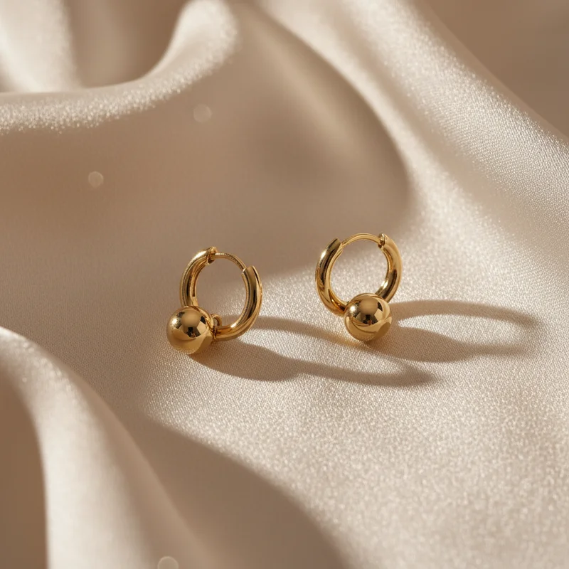 Elegant gold hoop earrings on satin