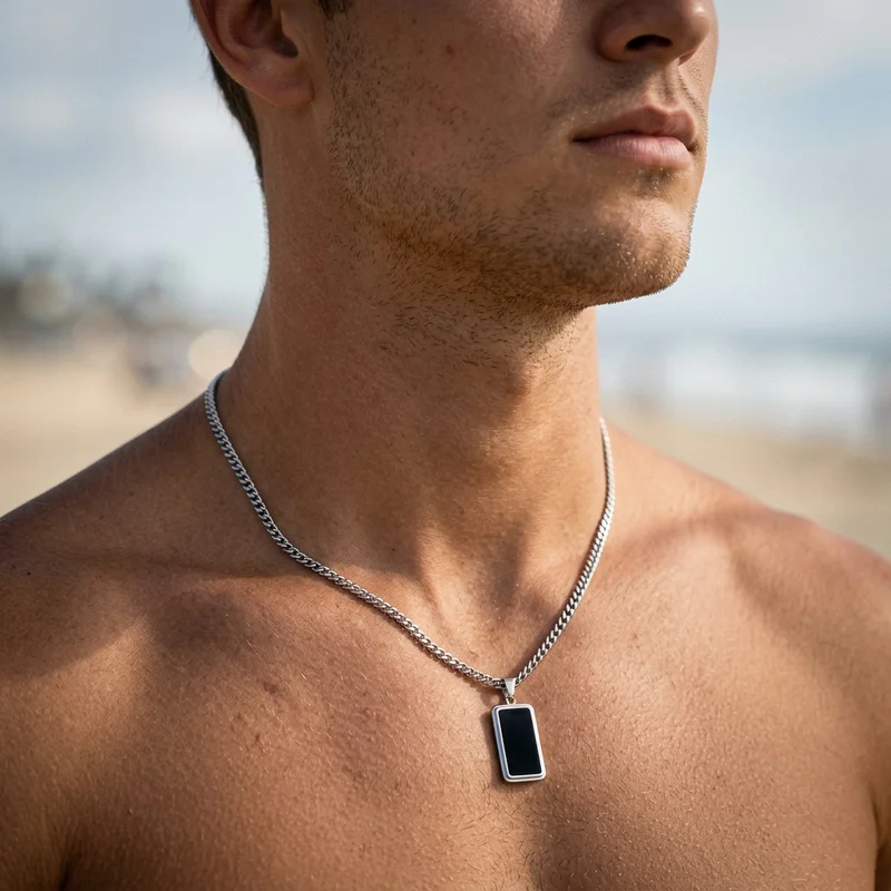 Men's silver necklace on beach