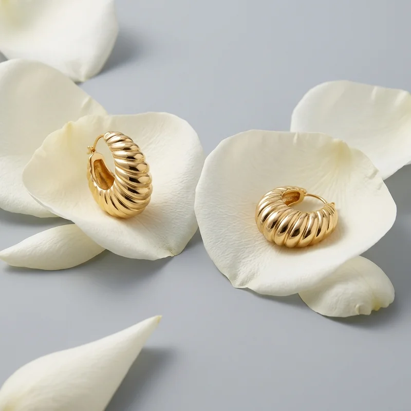 Gold hoop earrings on white petals