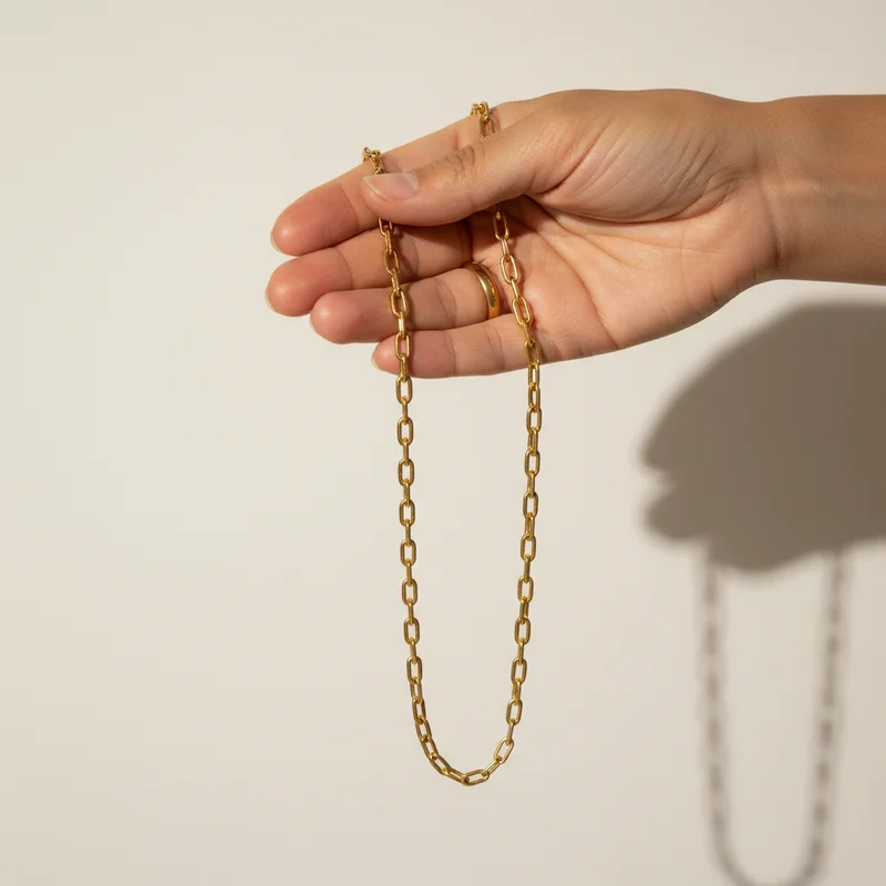 Minimalist gold chain held by hand