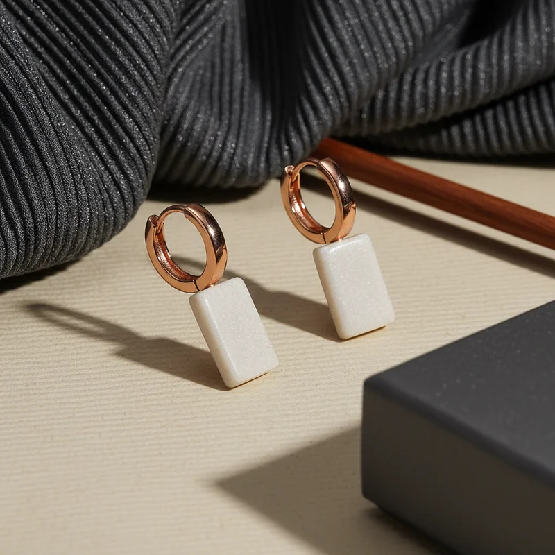 Elegant earrings on textured surface