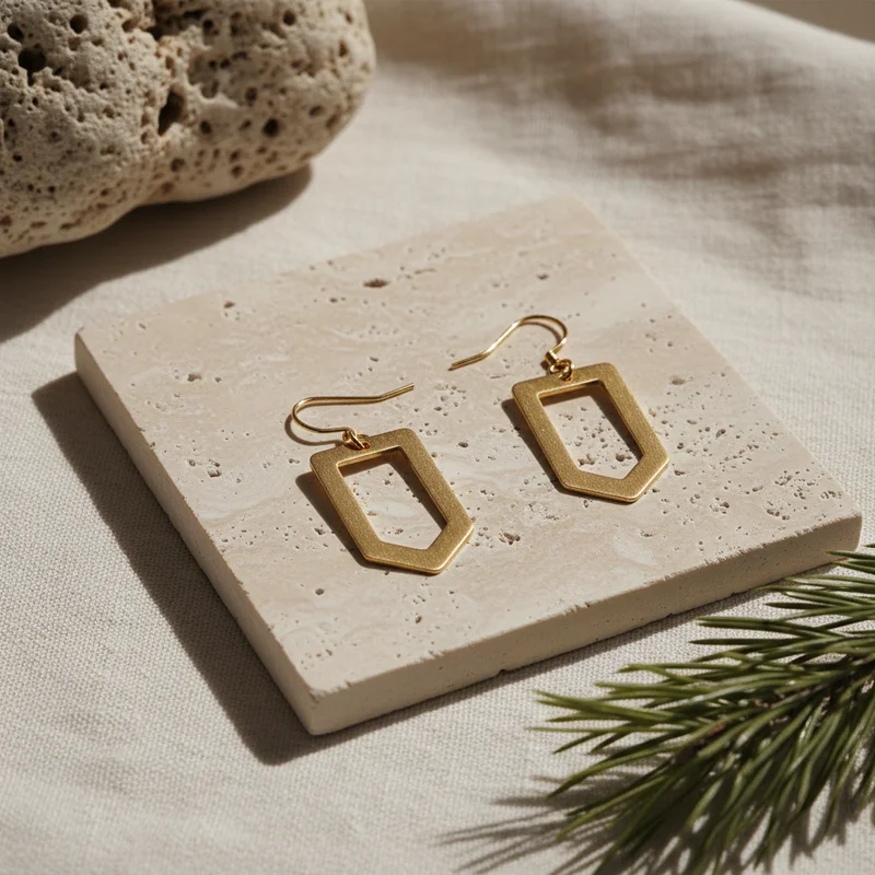 Geometric gold earrings on stone