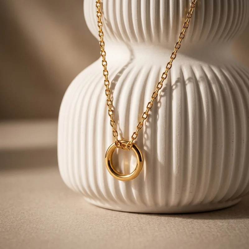 Gold circle necklace on ribbed vase