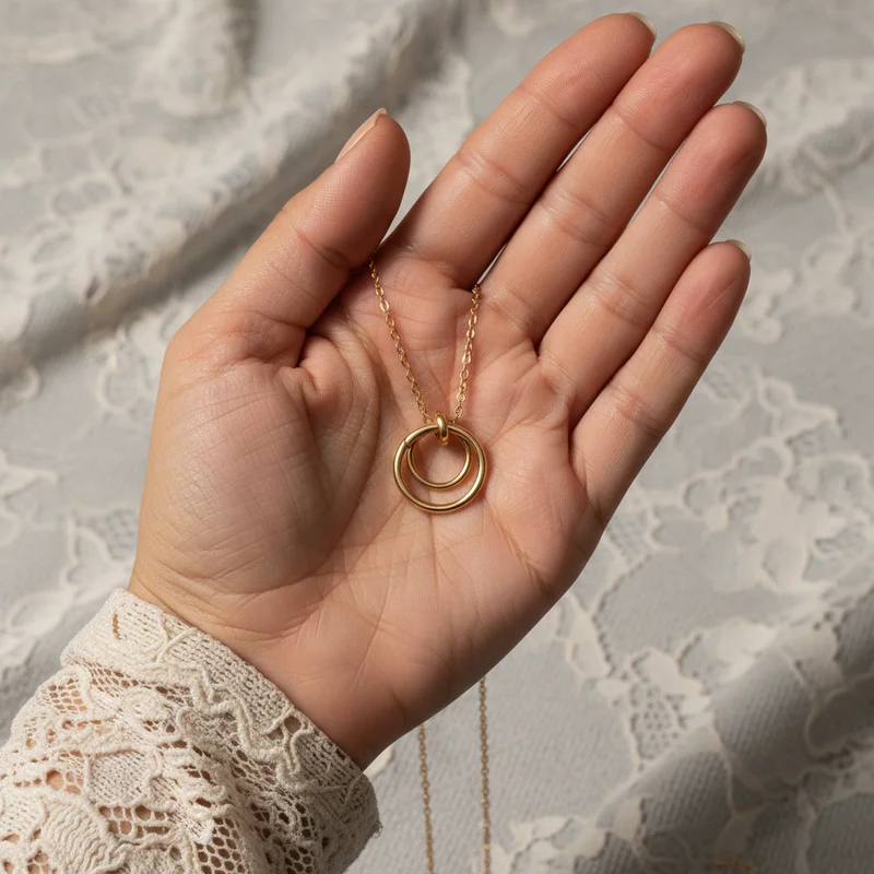 Delicate gold necklace on hand