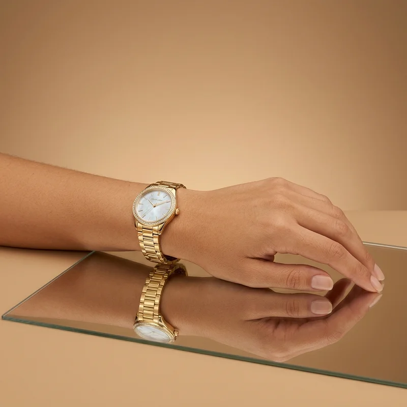 Elegant gold watch on mirror