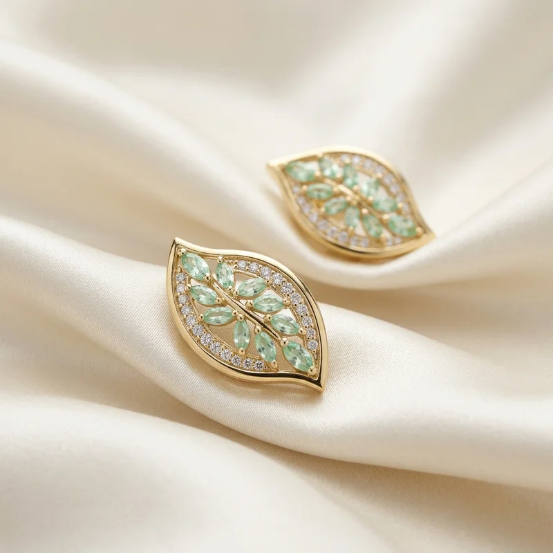 Elegant gold leaf earrings on silk