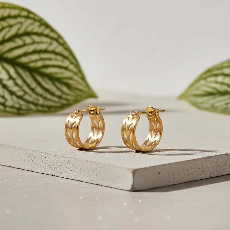 Gold leaf earrings on concrete