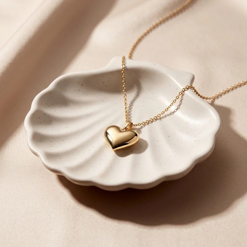 Gold heart necklace in shell dish