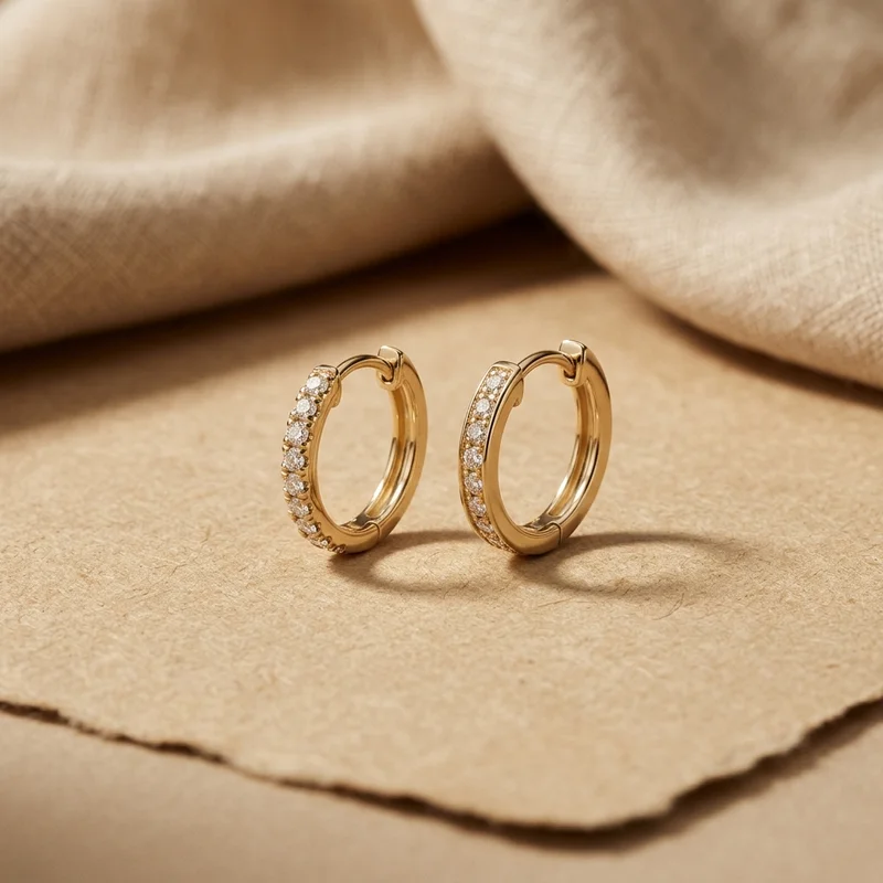 Gold diamond hoop earrings on paper