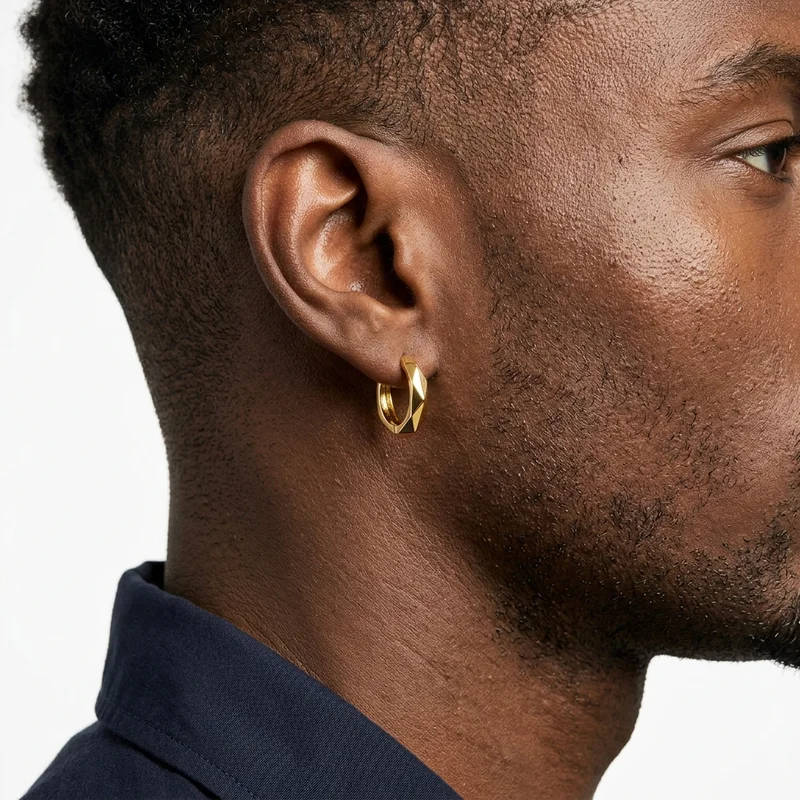 Faceted gold hoop earring on model
