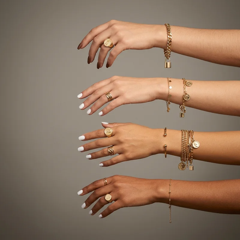 Stacked gold jewelry on hands