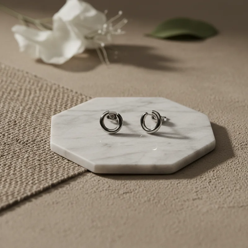 Minimalist silver earrings on marble