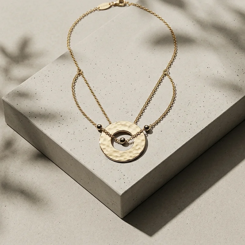 Modern gold necklace on concrete