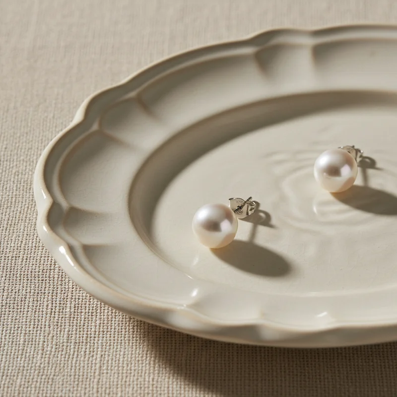 Elegant pearl earrings on ceramic