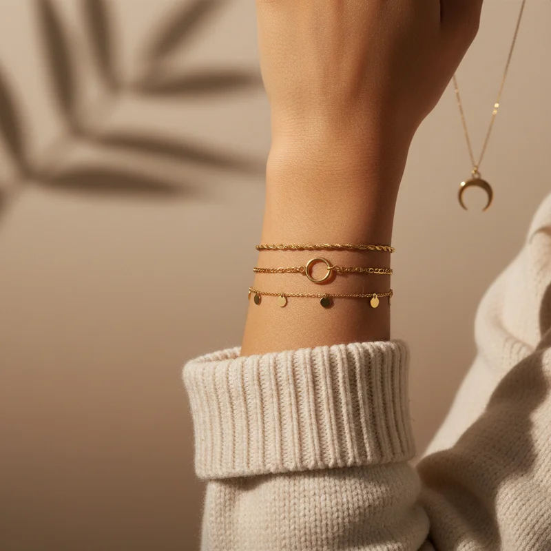 Gold bracelets on wrist with leaf shadow