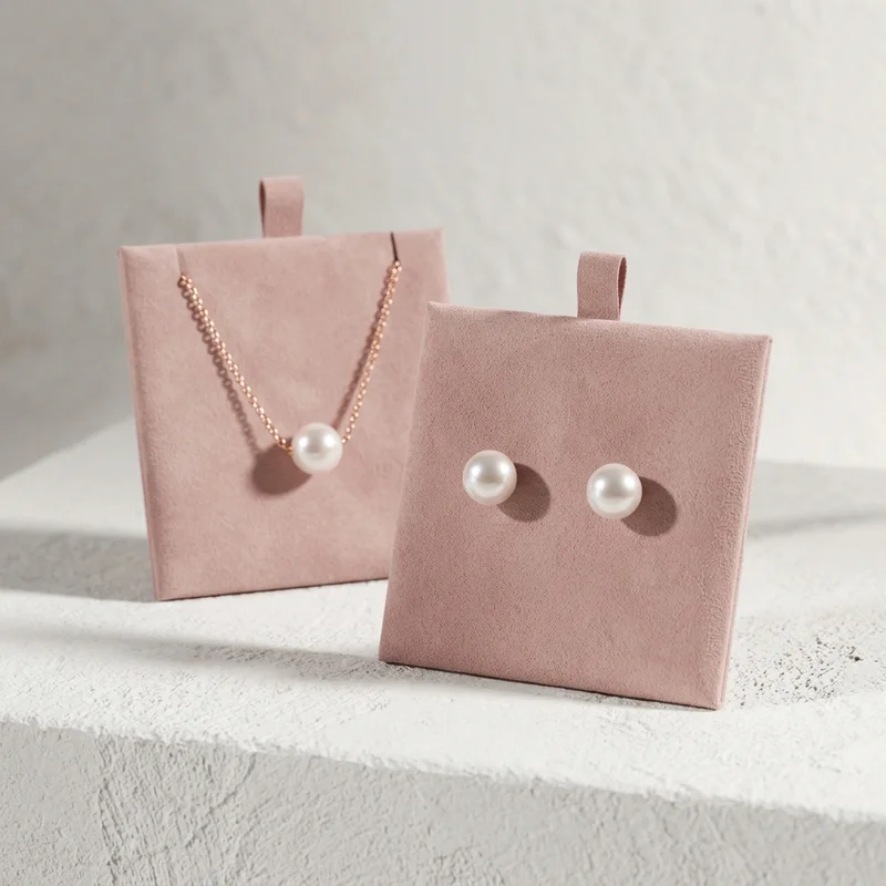 Elegant pearl jewelry on pink suede