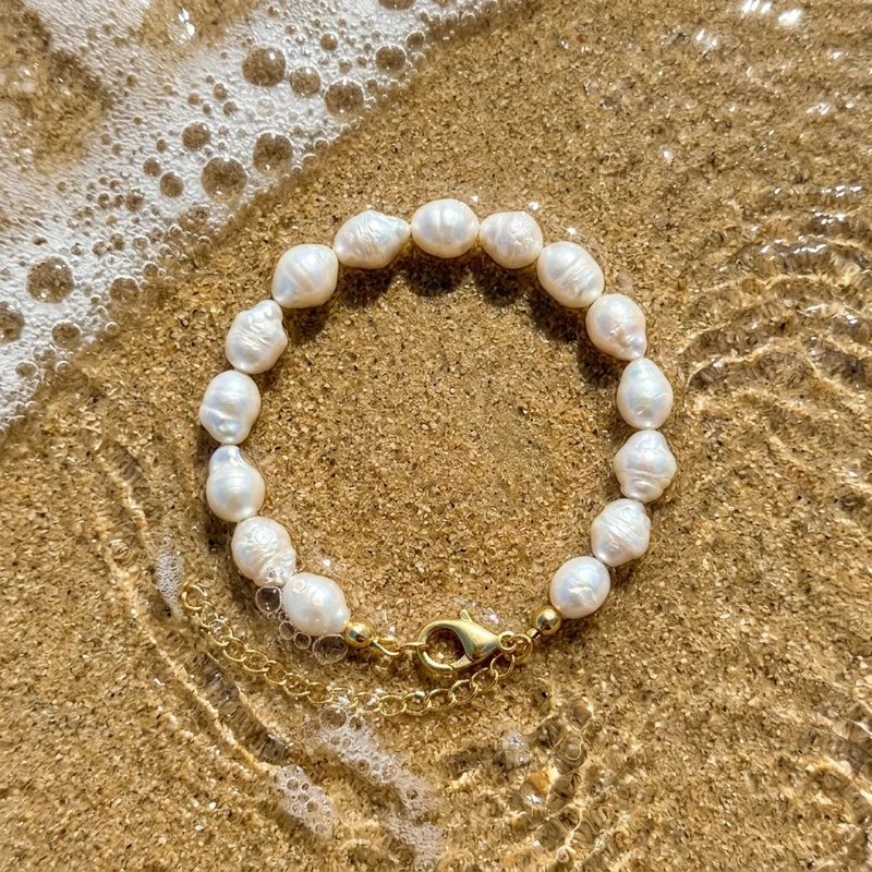 Baroque pearls on beach sand